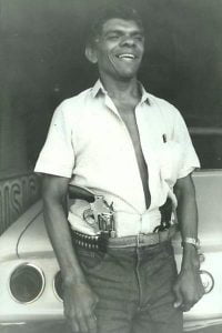 Diante de seu Opala e portando duas armas e um cinto com balas, Chico Pé de Pato posa para reportagem do "Notícias Populares" na zona leste de São Paulo – Foto: José Maria da Silva - 26.ago.1985/Folhapress