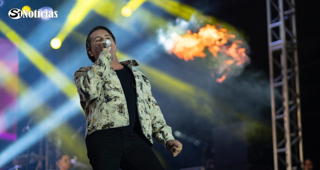Cantor se apresenta sob iluminação de palco durante a 56ª Festa dos Romeiros de Solidão.